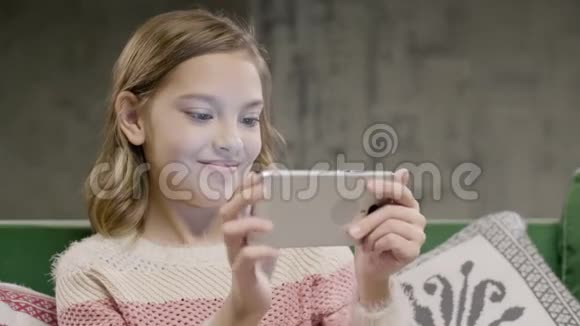 年轻女孩在智能手机上进行情感游戏视频的预览图