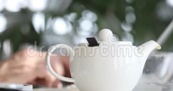 男性手打字笔记本电脑背景的Teapot视频的预览图