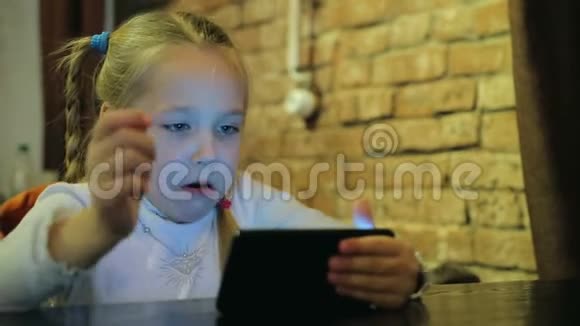 咖啡馆里有智能手机的快乐女婴视频的预览图