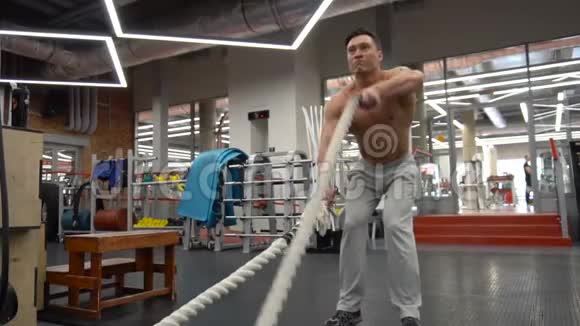 强壮的男人在健身房和战斗绳索一起工作视频的预览图
