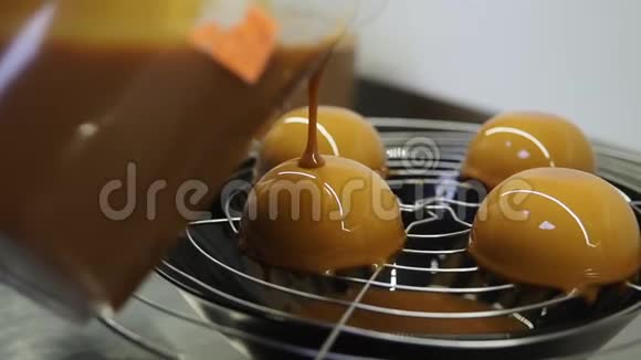 创造美味甜点的过程用玻璃覆盖烤蛋糕上面第二层焦糖特写视频的预览图