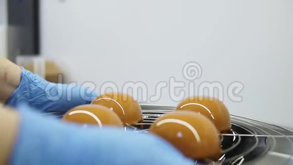 不可辨认的糖果手戴蓝色手套带着一个带釉面蛋糕的托盘离开完成准备视频的预览图