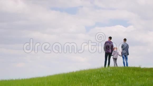 三个孩子两个青少年和一个6岁的女孩站在一座青山上期待地平线梦想视频的预览图