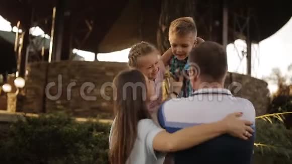 日落时公园里幸福家庭的拥抱视频的预览图