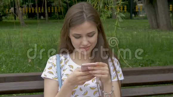 一个漂亮的白人女孩正在智能手机上读短信我有好消息和喜事笑笑心情好视频的预览图