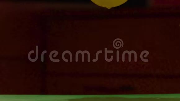 一个潮湿的绿色表面上的黄色柠檬瀑布视频的预览图