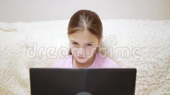 小女孩坐在沙发上看笔记本电脑上的插图视频的预览图