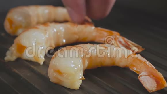 大虾在平底锅里烤煮熟的手放下锅里的虾视频的预览图