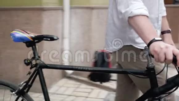4k镜头年轻人走出通道坐在老式运动自行车上视频的预览图