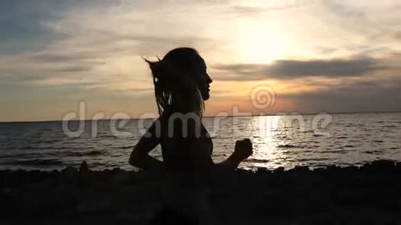 日落时在海边慢跑的年轻健身妇女视频的预览图