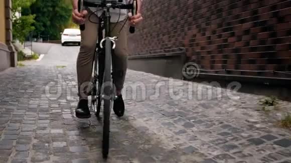 年轻人在老街上骑自行车的4ksteadicam视频视频的预览图