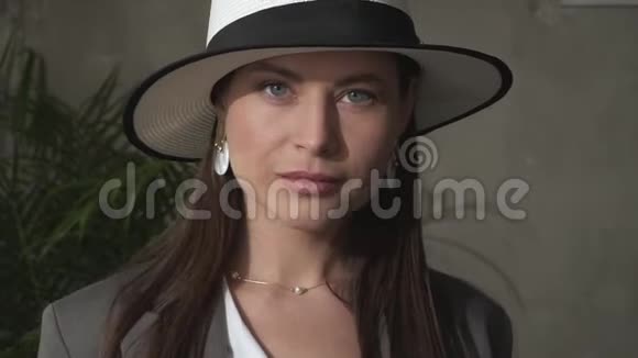 美丽的年轻黑发戴着优雅的帽子和商务套装视频的预览图