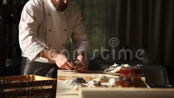 豪华餐厅的厨师打开牡蛎把它们放在装有冰块的盘子里视频的预览图