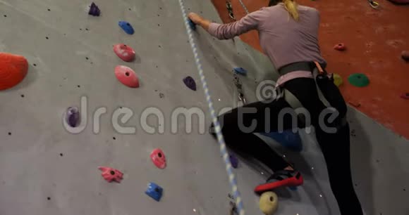 教练协助一名女子攀登人造墙视频的预览图