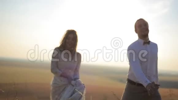 在风景如画的乡村背景下美丽男人和女孩沿着田野走了一天视频的预览图