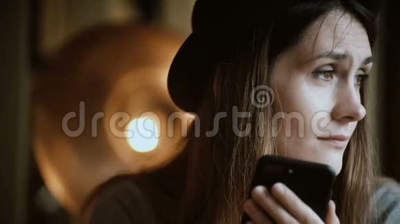 吸引人的年轻女人拿着智能手机在参观城市咖啡馆时使用无线技术的肖像视频的预览图