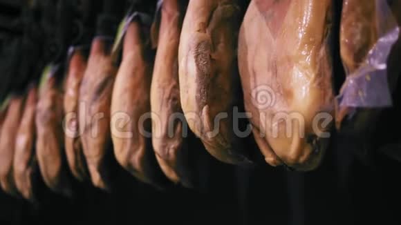 一段火腿挂在杂货店肉道上的片段没有品牌或标签可见视频的预览图