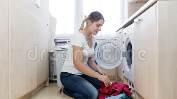 4k视频年轻家庭主妇闻脏臭袜子并扔进洗衣机视频的预览图