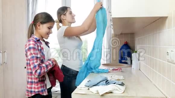4K美丽的微笑女孩帮妈妈洗衣服做家务的镜头视频的预览图