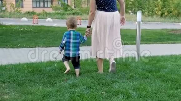 在公园里和妈妈一起散步的可爱赤脚幼儿男孩的慢动作镜头视频的预览图