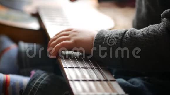 一个小男孩在家玩吉他视频的预览图