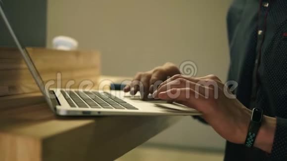 男性手在笔记本电脑键盘和滚动网页上打字视频的预览图
