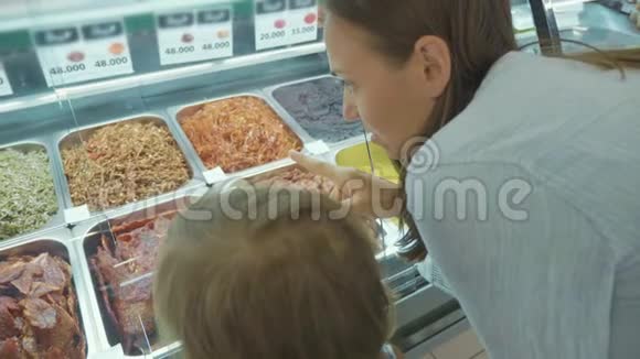 年轻的母亲和小女儿选择超市里的现成饭菜视频的预览图