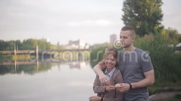 在河边的约会中找到一男一女美丽的女孩打破面包扔进水里视频的预览图