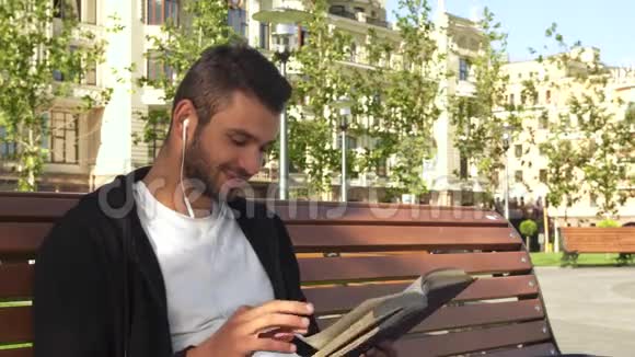 一个快乐的人在城市小巷里看书视频的预览图