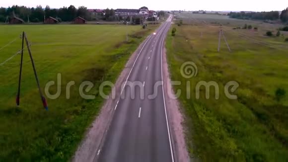 在乡村公路上骑摩托车的人的空中射击视频的预览图
