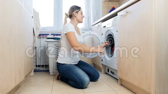 欢快的家庭主妇在洗衣服和扔衣服时玩得开心的慢镜头视频的预览图