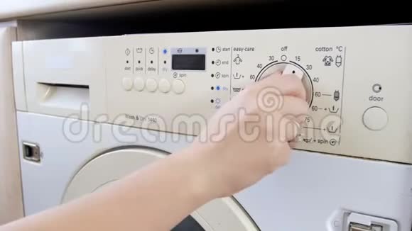 4k拍摄的年轻女性在洗衣机上选择温度和程序的特写镜头视频的预览图