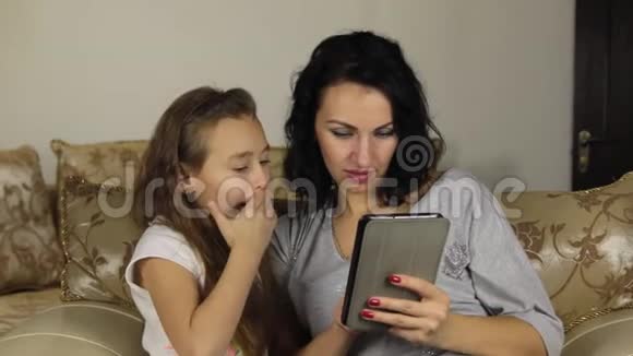近似变焦女儿教妈妈在平板电脑上玩游戏视频的预览图
