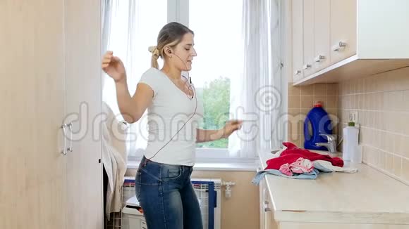 快乐快乐的家庭主妇在洗衣时跳舞的慢动作视频视频的预览图