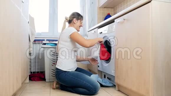 慢镜头视频快乐的笑女从洗衣机里拿出衣服扔空气视频的预览图