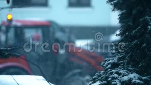 拖拉机和公路工人在冬天在一条街上做除雪工作慢镜头视频的预览图