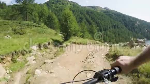在湖边的下坡上骑着电动自行车mtb行动骑自行车者探索近山的小径电动自行车视频的预览图