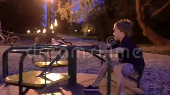 两个男孩在操场上露天享受夜晚男孩子们在晚上玩滑板视频的预览图