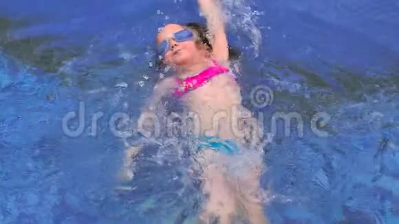 小可爱的女孩游到蓝色的游泳池边上视频的预览图