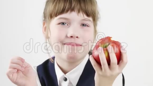 快乐漂亮的女学生吃红苹果视频的预览图