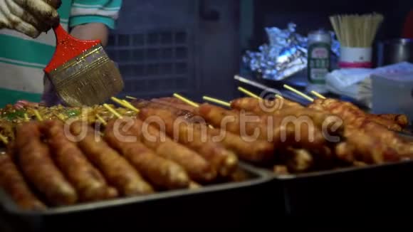 慢动作供应商在棍子上煮台湾鸡肉夜市街视频的预览图