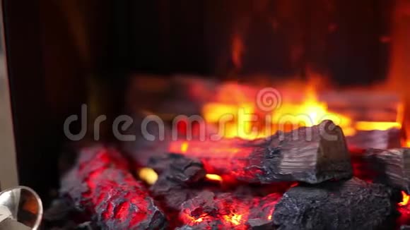 电壁炉内燃烧火焰和圆木的特写视频的预览图