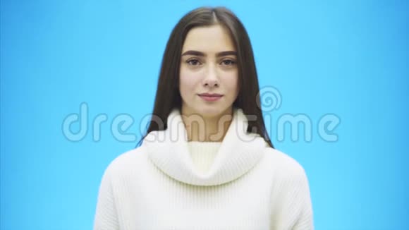一位穿着白色温暖毛衣的快乐年轻女人的肖像在这段时间里一个手势显示和感觉视频的预览图