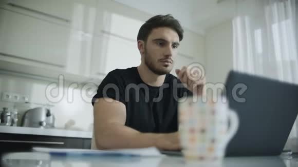 一个严肃的男人在家里用笔记本电脑体贴的商人视频的预览图