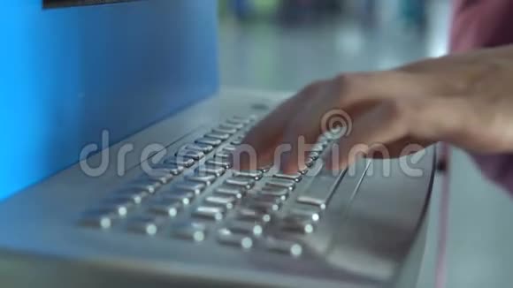 女孩的手在机场值机亭键盘上填写自己的名字以便在机场候机楼领取机票视频的预览图