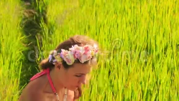 花圈里的年轻美女坐在绿草中视频的预览图