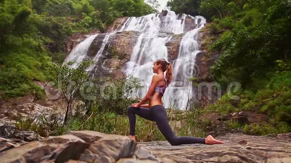 近距离侧景女孩扎着马尾在瑜伽姿势瀑布视频的预览图