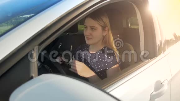 年轻女司机戴墨镜驾驶汽车的慢镜头视频的预览图