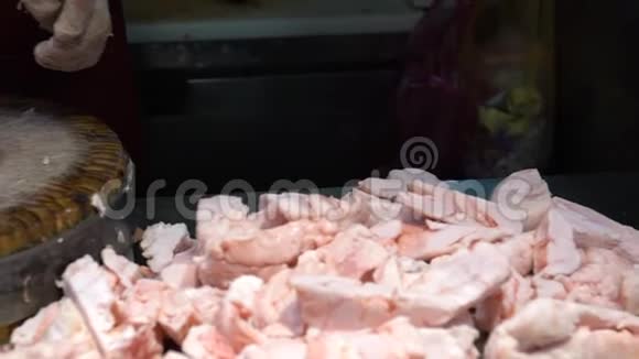 慢动手的猪肉店老板使用刀切生肉在木板上视频的预览图