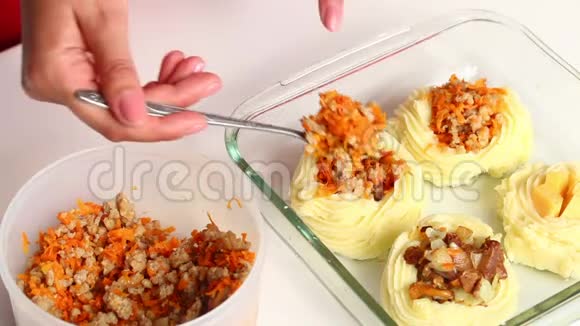 一个女人正把胡萝卜碎肉放在烤盘上的土豆泥里视频的预览图
